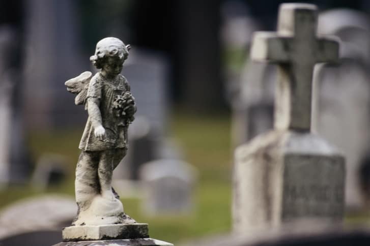 nagrobki i posąg na cmentarzu